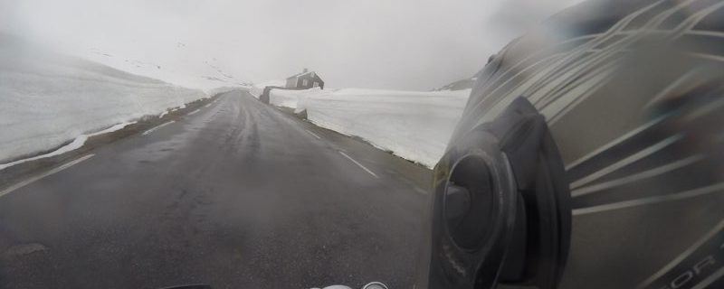 Fahrt mit dem Motorrad zwischen Schneewänden