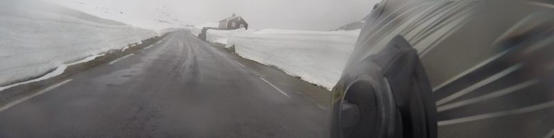 Fahrt mit dem Motorrad zwischen Schneewänden